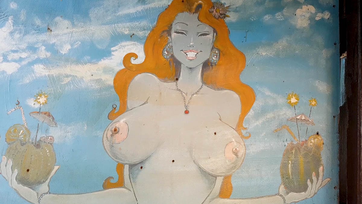 Wall painting in Matala showing a topless lady serving coktails